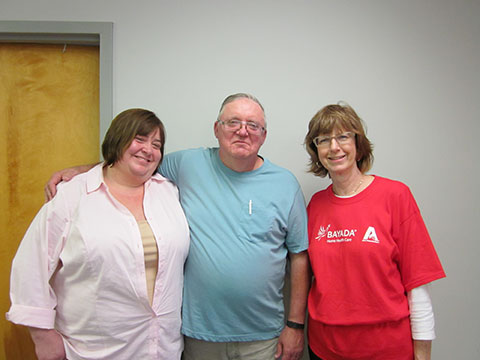 Mary's husband and daughter pictured with her caregiver, Pat